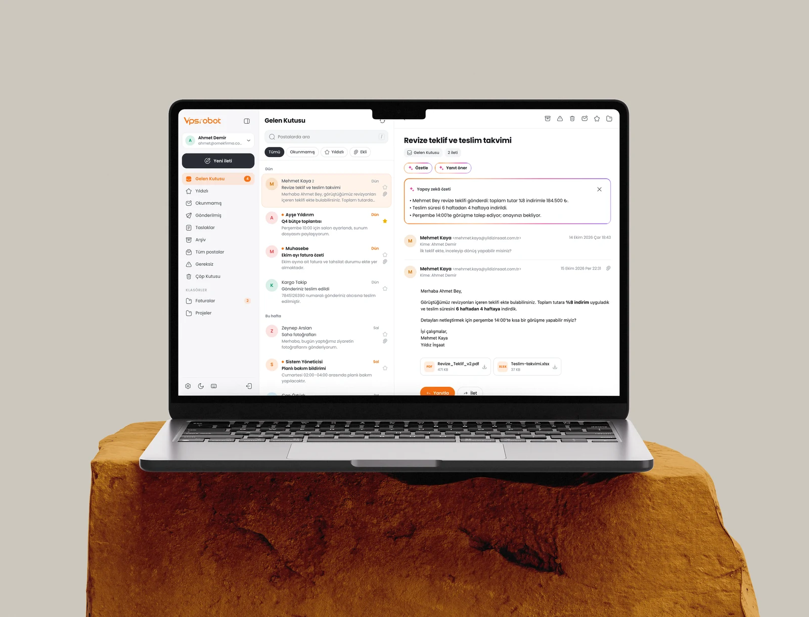 Taş kaide üzerindeki MacBook’ta web posta: gelen kutusu ve yapay zekâ özeti
